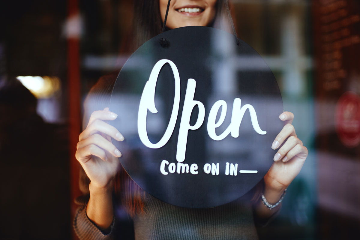 Open Come On In sign hanging in front door of a business with employee benefits in McAllen